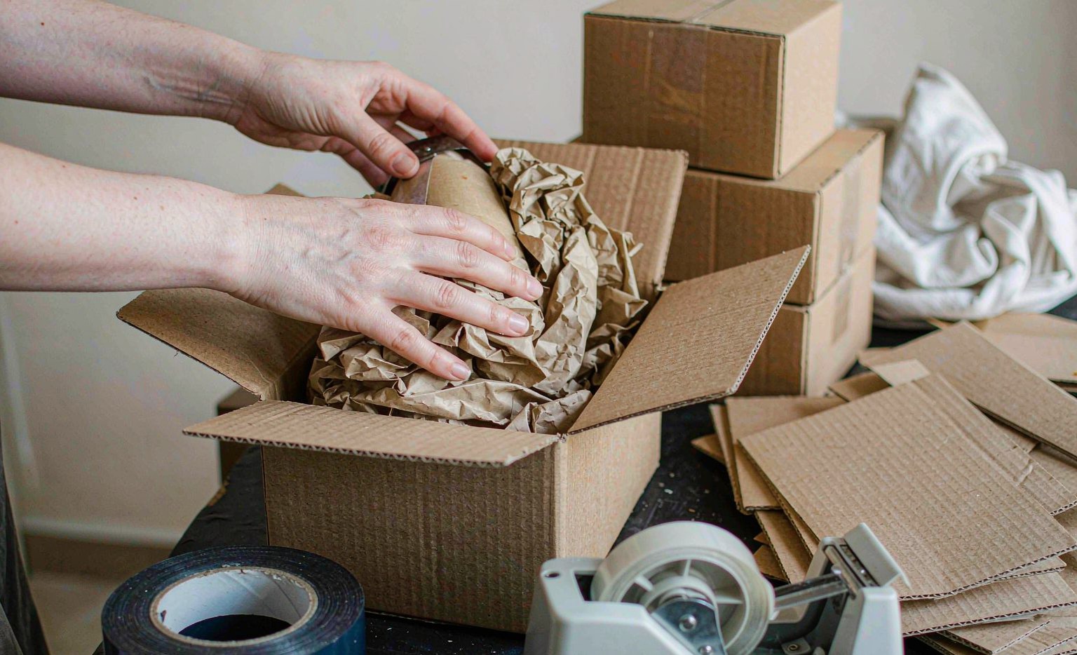 Packing a product into a cardboard carton at a packing bench