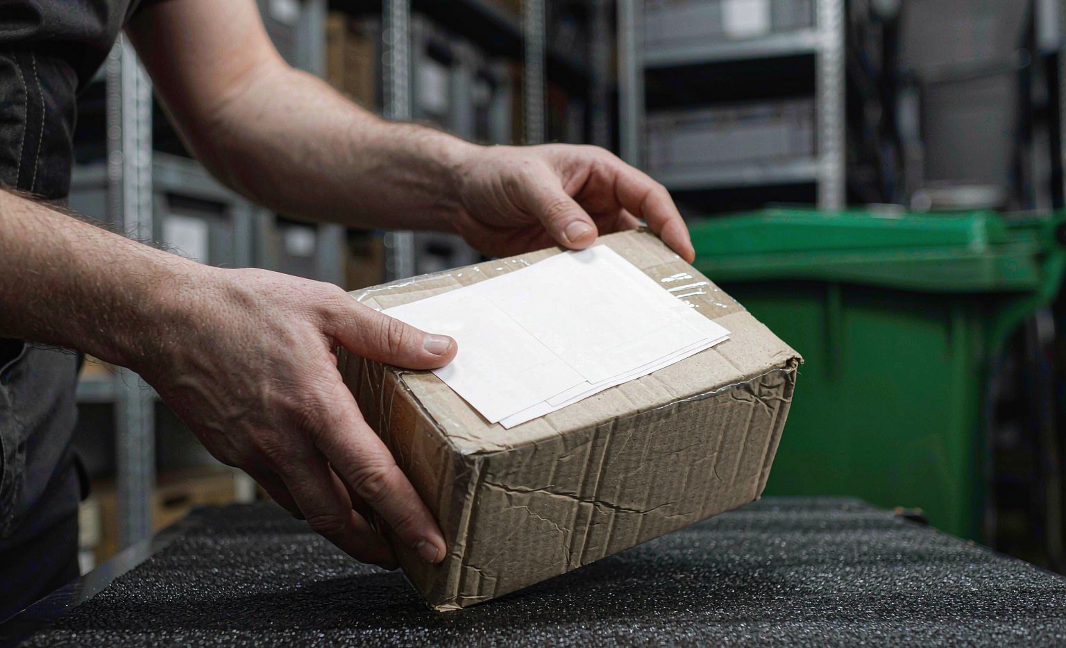 Applying a shipping label to a taped cardboard parcel