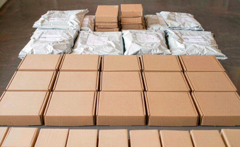 Assorted custom mailer boxes and poly bags arranged in batches for a dropshipping store