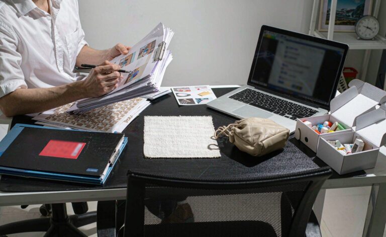 Sourcing manager comparing supplier catalogs and product samples at a work desk