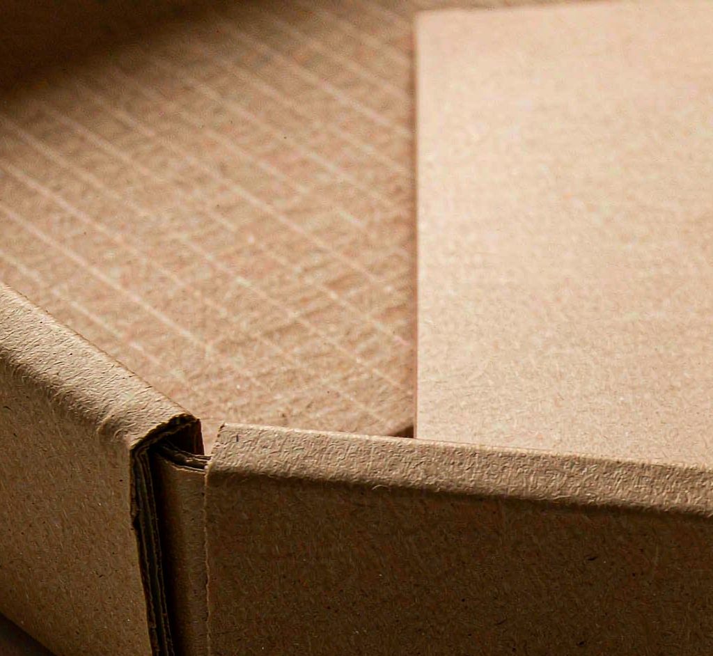 Macro detail of a kraft corrugated mailer box showing its flute structure and wall strength