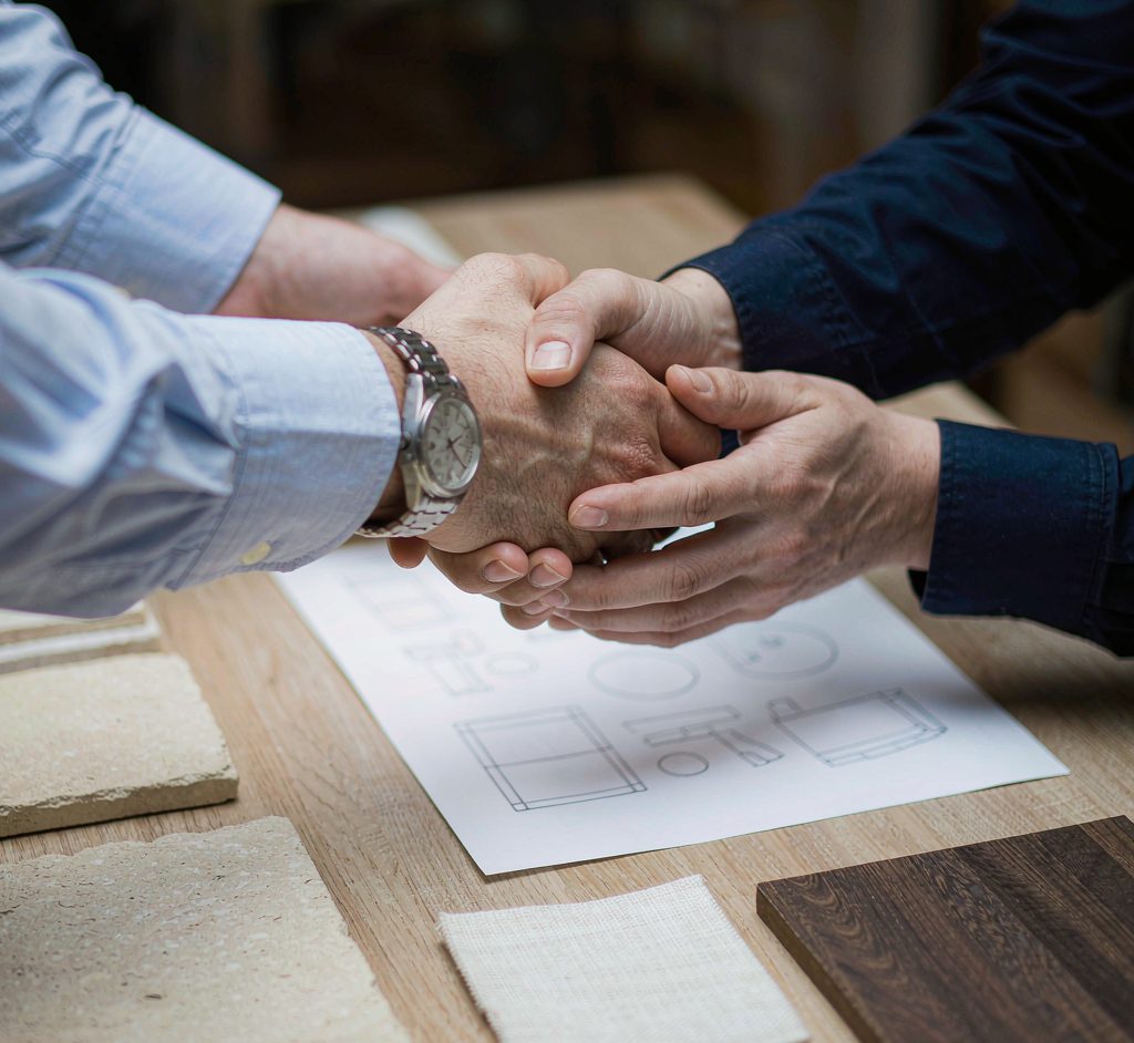 Buyer and supplier handshake over product drawings and material samples